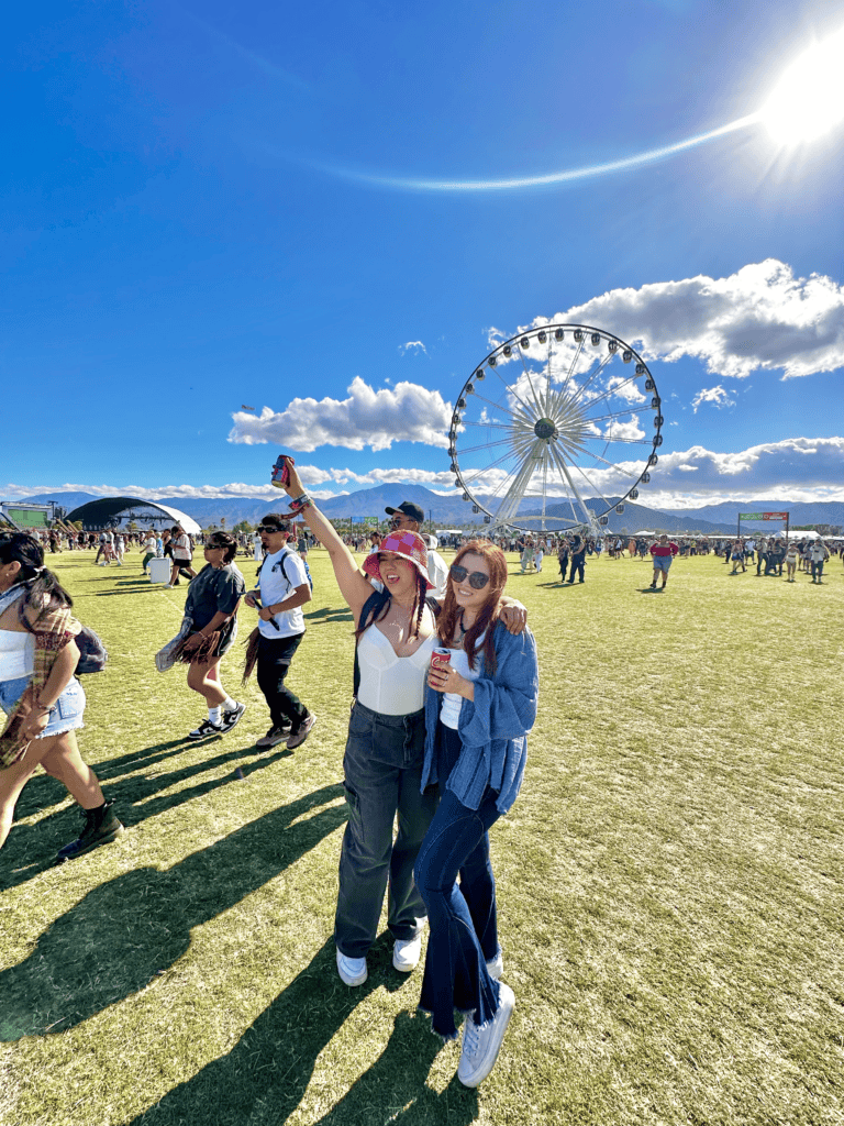 Jasmine Del Toro at Coachella in casual festival outfits – a white corset top with dark wide-leg jeans and a red bucket hat, and a denim jacket with flared jeans and sunglasses, with the iconic Coachella Ferris wheel in the background