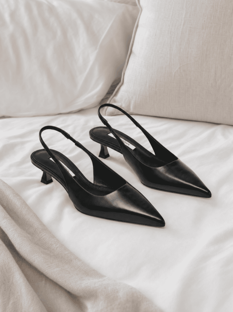 Black pointed-toe slingback kitten heels on a white bed, the classic style in this guide to the best Amazon slingback heels